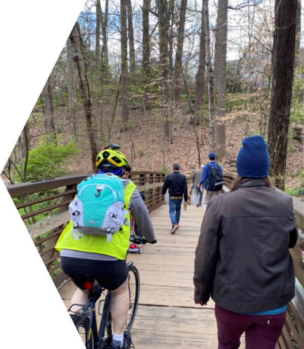 Pedestrians and bicylists crossing a trail bridge.